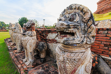 在泰国阿尤塔亚的Thammikarat寺庙 由狮子雕像Cambodia风格环绕着古董斯塔帕废墟崇拜佛教徒佛塔宝塔文化天空石头建筑图片