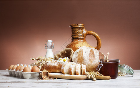 木制旧餐桌上的新鲜烤面包 蜂蜜和鸡蛋小麦谷物燕麦面粉木头食物产品纤维食品玉米图片