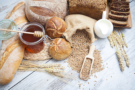 燕麦面包早餐 面包面包 各种小麦耳食面包和草纸牛奶烹饪炊具生活大麦作品烘烤馒头蜂蜜农业背景
