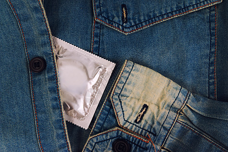 旧的蓝色牛仔裤口袋里有避孕套 专注安全套纺织品橡皮男人性别控制风险乳胶避孕卫生疾病图片