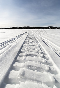 湖边的雪雪移动轨道森林树木摩托白色蓝色雪地天空曲目图片