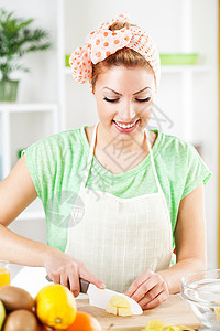 切割苹果的年轻妇女金发喜悦成人菜刀食品头巾快乐女性砧板水果图片