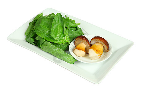 白色盘子上的新鲜蘑菇和菠菜 孤立于图片