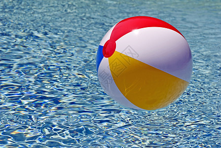 游泳池中闪亮的彩色海滩球漂浮图片