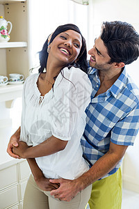 快乐的年轻情侣相互拥抱混血闲暇女性服装家庭亲密感夫妻公寓男性乐趣图片