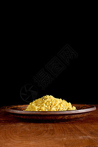 里索托和山红花在木制桌上黄色粮食香菜食品藏红花美食乡村素食午餐桌子图片