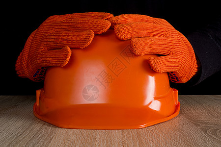 橙色建筑头盔掌握在手中商业衣服工作帽子男性危险职业安全帽工业工具图片
