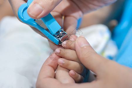 母亲切割婴儿指甲儿童新生皮肤护理修剪蓝色白色男生孩子男性背景图片