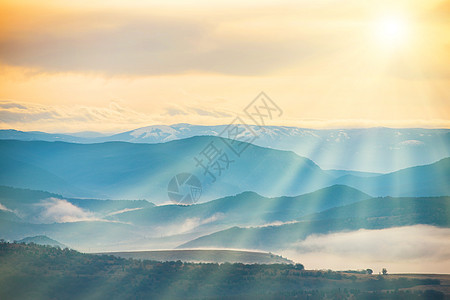 蓝色的山岳 被雾雾笼罩太阳日出风景薄雾太阳光线阴影爬坡环境日落大路图片
