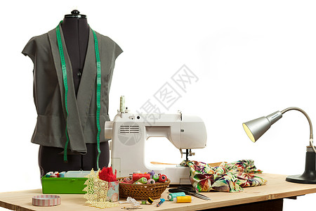 一张桌子上的缝纫机费用机械纺织品艺术机器配件衣服材料线程白色磁带图片