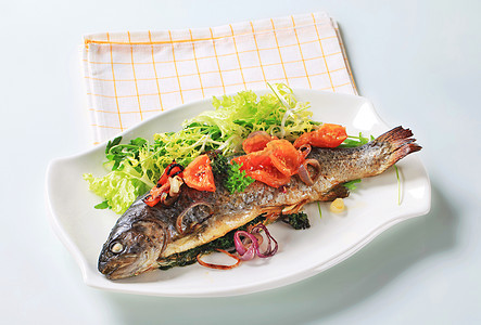有番茄和绿色沙拉的烤鳟鱼盘子青菜沙拉草药洋葱美食午餐白色食物营养图片