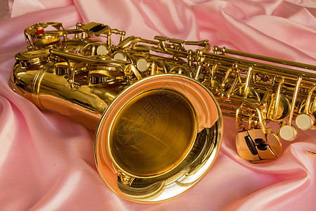 金色萨克斯管床单被单丝绸艺术奢华喉舌萨克斯管折痕金子背景图片