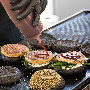 牛肉汉堡准备在食物摊位上吃盘子敷料炙烤餐饮小吃桌子大车城市沙拉手套图片