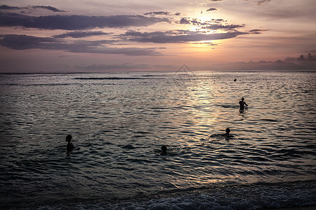 儿童在海边日落中游泳图片