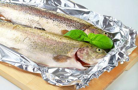 锡粉上两条新鲜的鳟鱼库存锡纸食物海鲜鲑鱼砧板皮肤食材铝箔图片