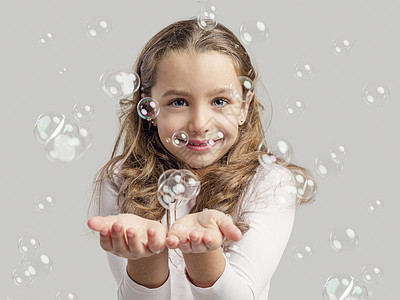 女孩玩肥皂泡沫微笑乐趣女性童年孩子喜悦孩子们儿童幸福图片