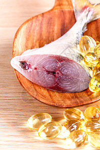 Omega 3个木勺上带新鲜鱼的鱼油囊疼痛治疗饮食保健药店养分药片金子营养维生素图片