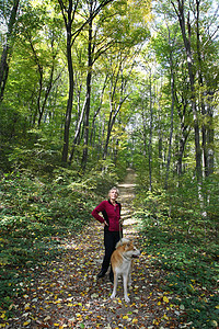 夫人和她的狗动物森林公园忠诚宠物小狗享受休息监护人女士背景图片