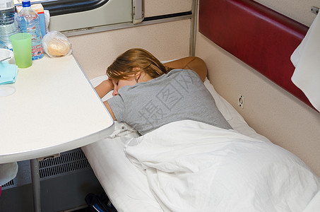 火车上的女孩在二等座轿跑车上双手抱在脑后趴着睡觉图片