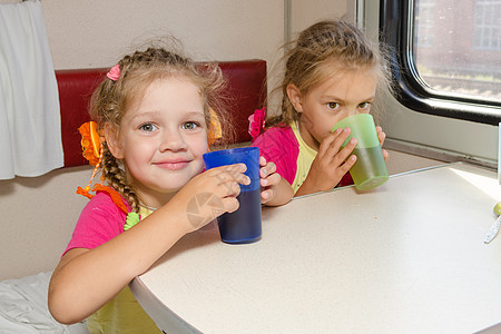 火车上的两个小姐妹在二等车厢下层的桌子上喝茶图片