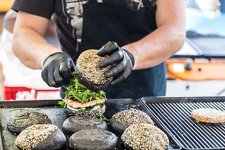 牛肉汉堡准备在食物摊位上吃午餐街道厨房美食小吃包子盘子炙烤手套城市图片