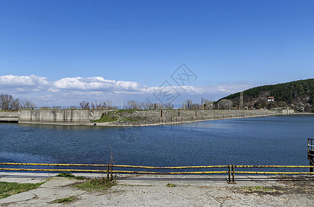 望向长相大坝的街堤墙松树花岗岩绿色森林顶峰天空白色弹幕蓝色图片