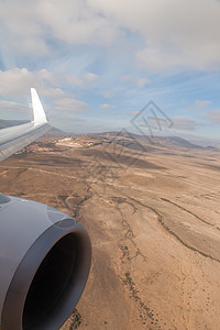 从飞机窗视图看岛风景天空空气旅行运输旅游翅膀土地飞行窗户图片