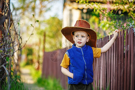 一个小男孩的肖像 站在一顶大帽子 在木棍上图片