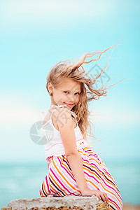一个在风中挥手的漂亮小女孩的肖像微笑海滨发型女性情感头发喜悦孩子乐趣卷发图片