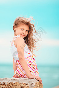 一个在风中挥手的漂亮小女孩的肖像情感裙子微笑女性喜悦头发棕褐色快乐女孩乐趣图片