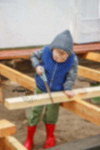 小工作室男孩在锯木板 家庭建筑 李建设者青年童年工具建筑师活动婴儿背心孩子男性图片