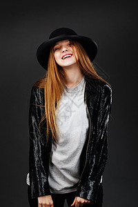 穿着黑色帽子和皮拉帽的漂亮年轻女孩的肖像皮革衬衫微笑夹克笑声青少年工作室金发女郎潮人情绪图片