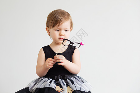 一个可爱小女孩的肖像 带着可笑的纸眼镜图片