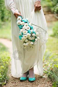 新娘手中的美丽的婚礼花束子珠子风格裙子丝绸仪式传统配偶装饰天蓝色蓝色图片