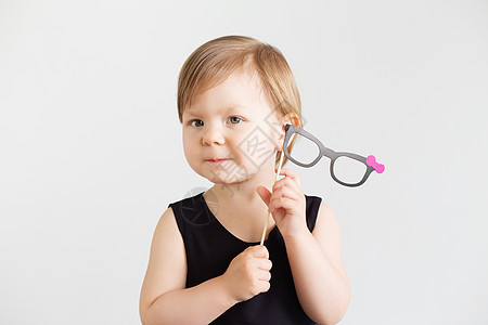 一个可爱小女孩的肖像 带着纸眼镜对着一个WH图片