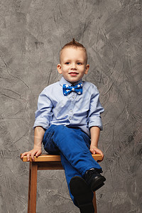 坐在高凳子上 一个有趣的小男孩的肖像图片