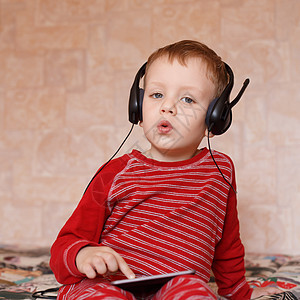 家里有耳机的小男孩婴儿青春期孩子倾听者歌曲音乐男性药片童年音乐播放器图片