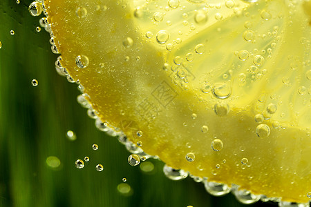 水背景中的柠檬与水滴图片