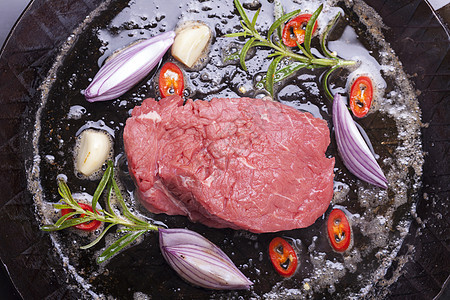 铁锅里生牛排洋葱牛肉香料牛扒灼烧黄油鱼片食物辣椒油炸图片