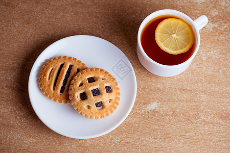 茶杯和柠檬 饼干加酱果酱 在表顶视图上桌子篮子柳条蛋糕食物甘蔗糕点勺子水果玻璃图片