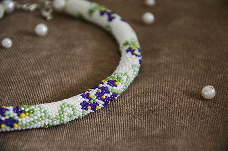 由白色 蓝色和绿色珠子组成的颈带图片