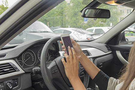 女孩坐在汽车车轮后面运输驾驶领航交通手指运动拨号挡风玻璃女性旅行图片