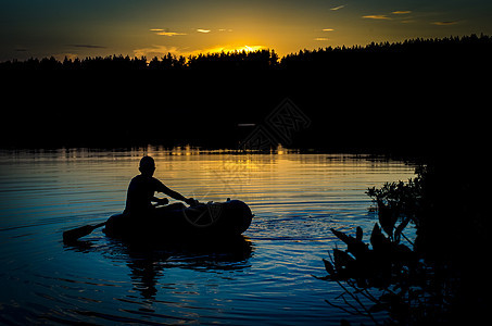 日落时乘船的渔民旅行渔夫风景休息蓝色海滩阳光支撑太阳天空图片