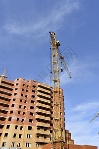 Craner和建筑建筑工地对蓝天框架住房水泥工程财产建筑学工人多层房子蓝色图片