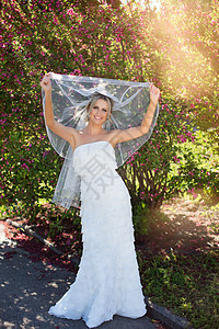 新娘礼服的秀丽新娘有花束和花边面纱的在自然 穿着白色婚纱的美女模特 在公园里的女性肖像 有发型的女人 户外可爱的女士夫妻头发婚礼图片