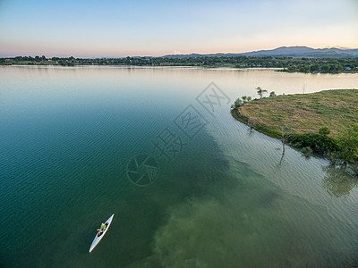 湖中独木舟和空中观察皮艇白色水库男性桨手天线航拍图片