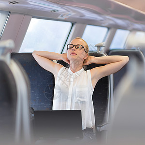 妇女在火车上行驶时窒息铁路管理人员通勤者女孩休息运输工作女性拉伸药片图片