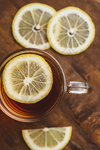 黑茶的顶端景色 杯中柠檬和木板桌杯子一杯茶食物茶碗草本植物早餐水果餐具飞碟桌子图片