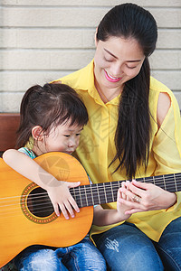 母亲和女儿一起弹吉他 家人在一起共度时光家庭娱乐教学音乐女性父母爱好享受吉他两个人图片
