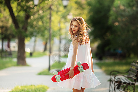 穿着白裙子和粉色溜冰鞋的可爱城市女孩的肖像图片